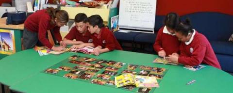This image shows children with books and photographs