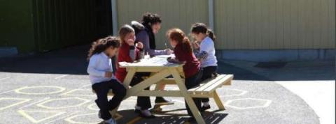 This image shows mother and children working on an outside table